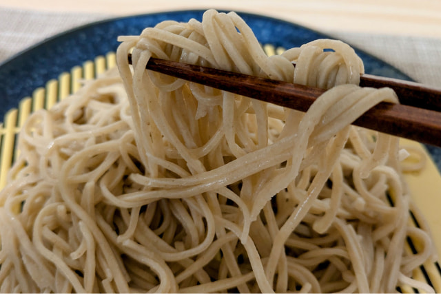 艶やかな蕎麦を箸でつまむ